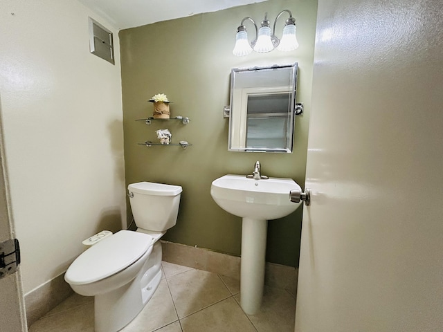 half bathroom with toilet, baseboards, visible vents, and tile patterned floors