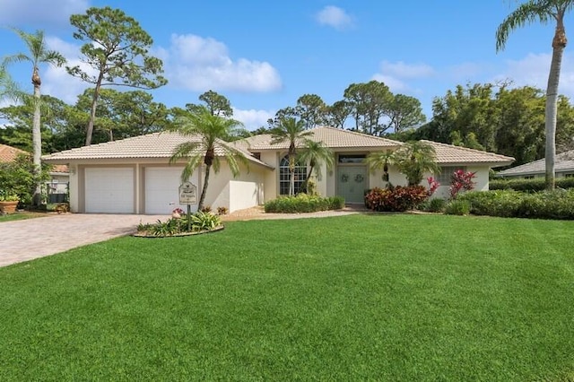 single story home with decorative driveway, stucco siding, a front yard, a garage, and a tiled roof