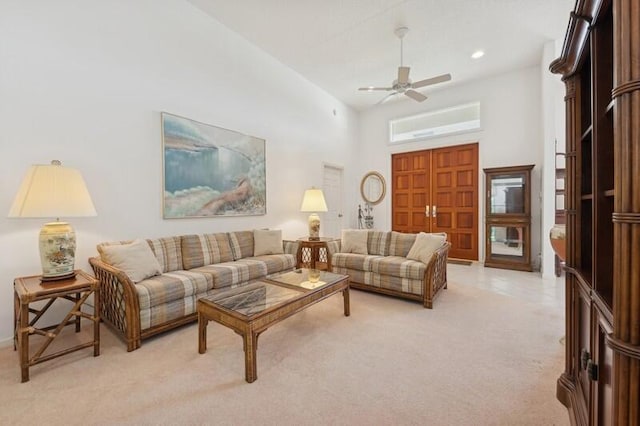 living area with recessed lighting, light carpet, ceiling fan, and a towering ceiling