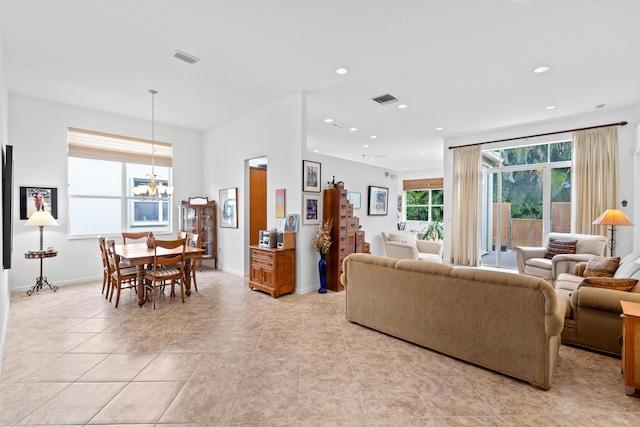 living room featuring baseboards, recessed lighting, visible vents, and a chandelier