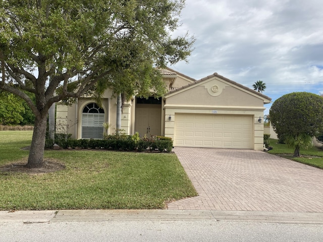 view of front of property with a garage, stucco siding, decorative driveway, and a front yard