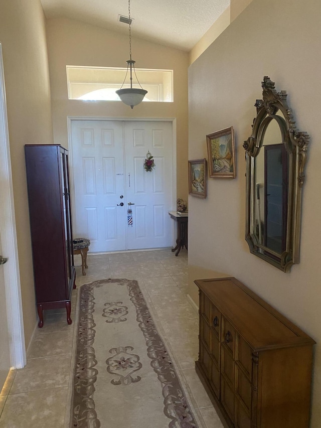 foyer entrance featuring lofted ceiling and light tile patterned floors