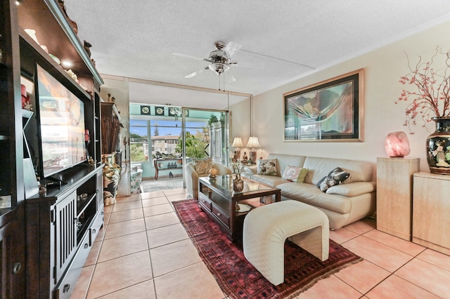 living room with a ceiling fan, light tile patterned flooring, crown molding, and a textured ceiling