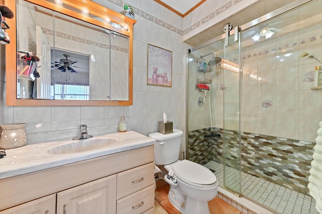 bathroom featuring decorative backsplash, toilet, vanity, a shower stall, and tile walls