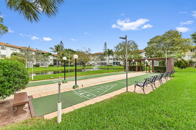 view of home's community with a lawn and a water view