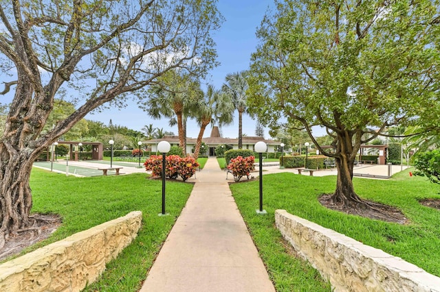 surrounding community with shuffleboard and a lawn