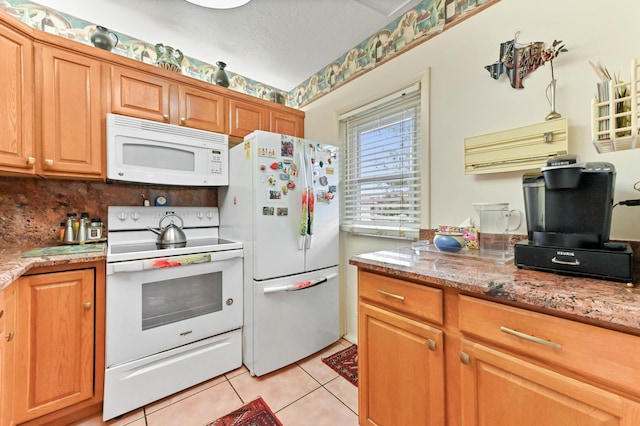 kitchen featuring light tile patterned floors, light stone counters, white appliances, brown cabinets, and decorative backsplash