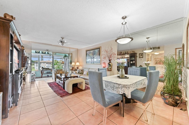 dining area featuring a ceiling fan, visible vents, light tile patterned flooring, and a textured ceiling