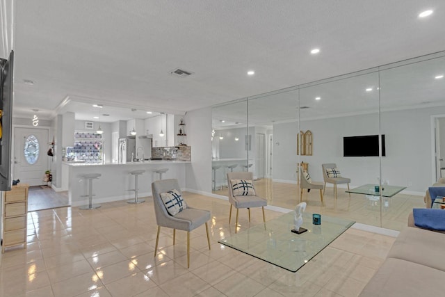 living room featuring light tile patterned floors, baseboards, visible vents, a textured ceiling, and recessed lighting