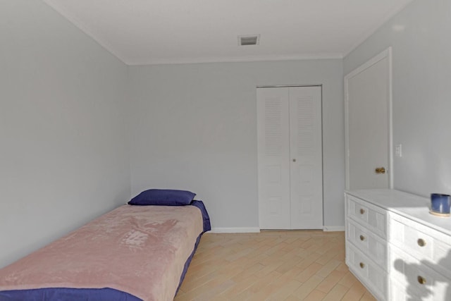 bedroom featuring light wood-style floors, visible vents, ornamental molding, and baseboards