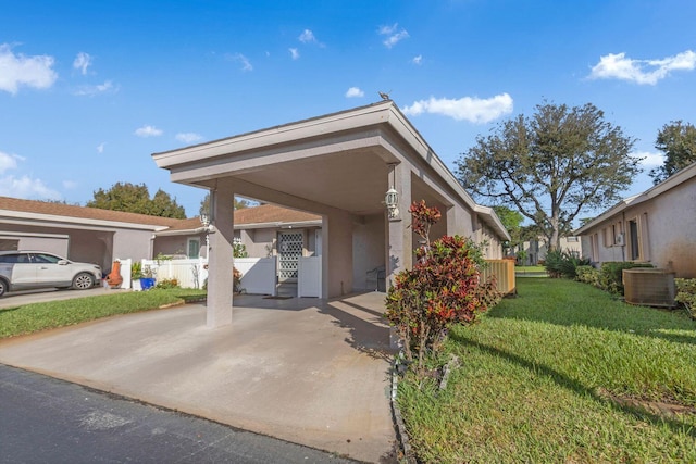 view of front of home featuring a residential view, fence, central air condition unit, a front lawn, and stucco siding