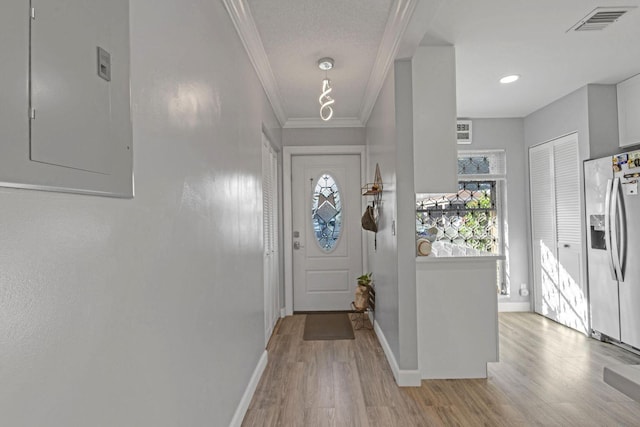 doorway featuring visible vents, baseboards, light wood-style floors, ornamental molding, and electric panel