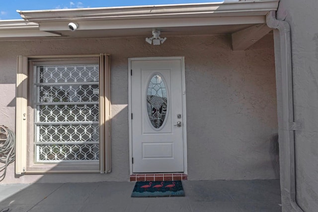 entrance to property featuring stucco siding