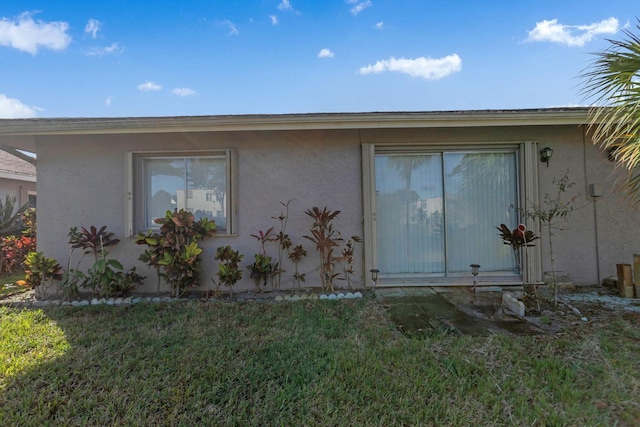 view of side of home featuring a yard and stucco siding