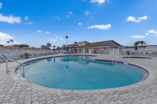 pool with a patio and fence