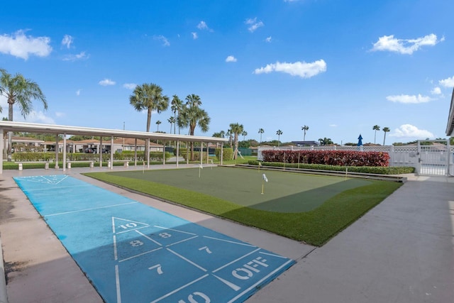 view of community featuring fence and shuffleboard