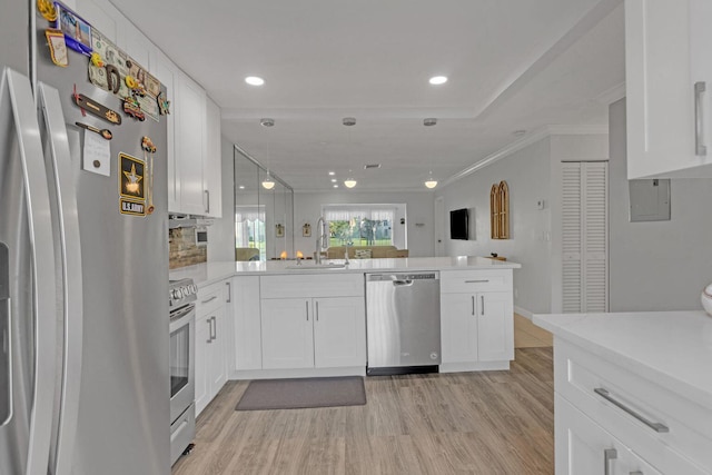 kitchen featuring a peninsula, a sink, stainless steel appliances, and light countertops