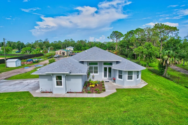 view of front of home featuring roof with shingles and a front yard