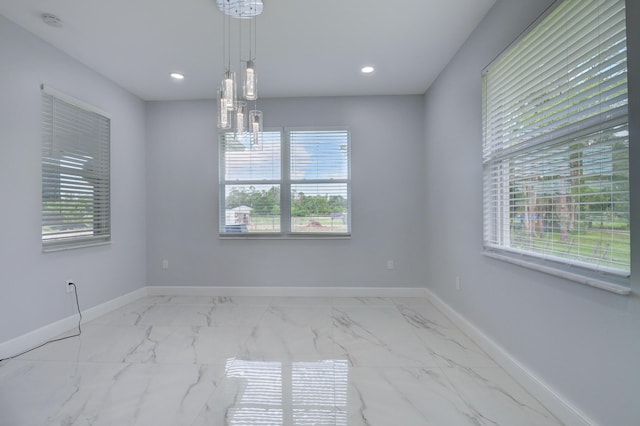 empty room with marble finish floor, recessed lighting, and baseboards