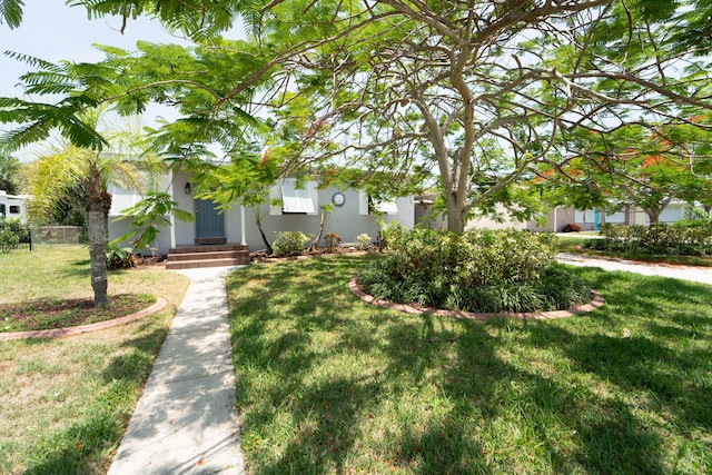 306 Fernandina St, Fort Pierce, FL 34949 - obstructed view of property featuring a front yard, stucco siding, and entry steps
