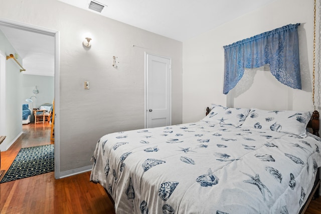 bedroom featuring baseboards, visible vents, and dark wood-style flooring