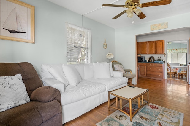 living area with light wood finished floors and a ceiling fan