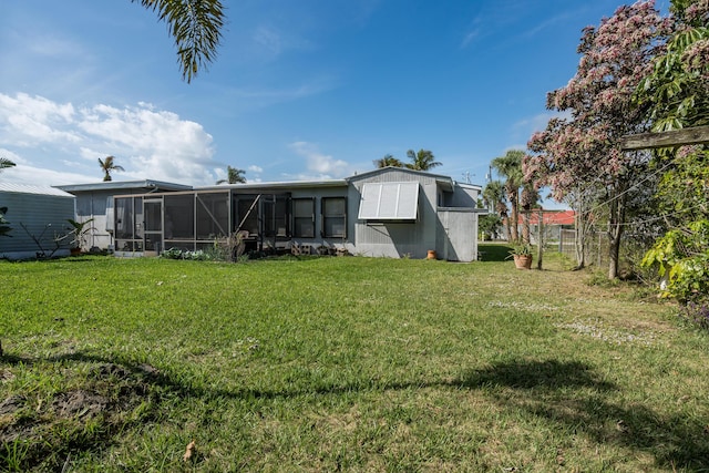 rear view of property with a sunroom and a lawn