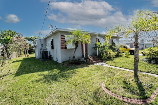 view of front of house with fence, a front lawn, central AC, and stucco siding