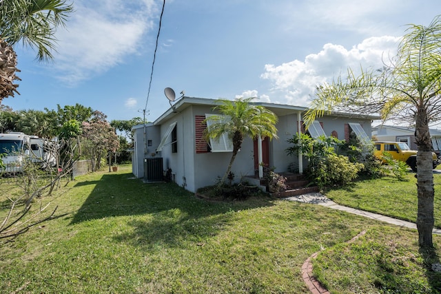 view of side of home featuring a yard, stucco siding, fence, and central air condition unit