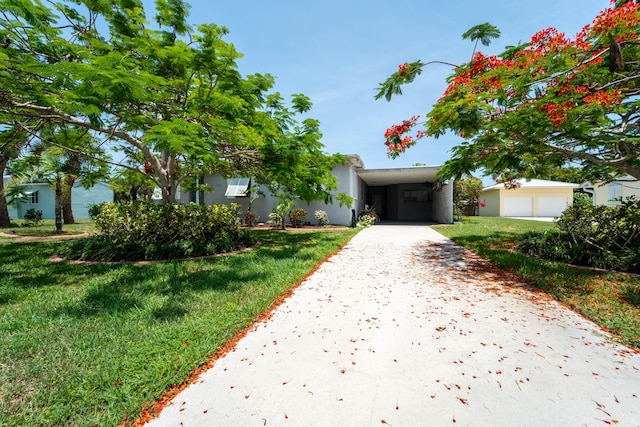 306 Fernandina St, Fort Pierce, FL 34949 - view of front of house featuring concrete driveway, a front lawn, a carport, and stucco siding