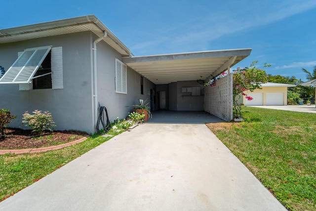 306 Fernandina St, Fort Pierce, FL 34949 - view of property exterior featuring stucco siding, concrete driveway, an attached carport, and a yard