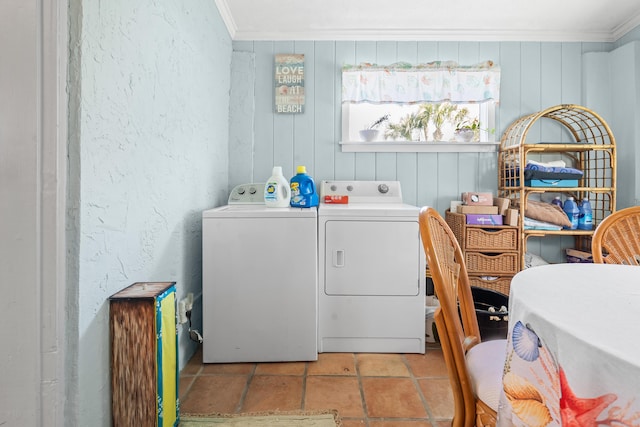 laundry area featuring a textured wall, laundry area, ornamental molding, and washing machine and clothes dryer