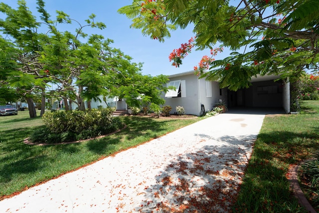 306 Fernandina St, Fort Pierce, FL 34949 - obstructed view of property featuring a front yard, stucco siding, and driveway