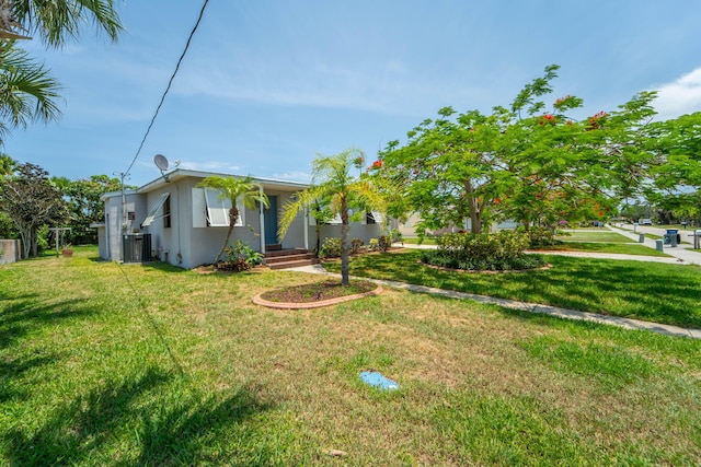 306 Fernandina St, Fort Pierce, FL 34949 - view of front of house with stucco siding, central AC unit, and a front yard