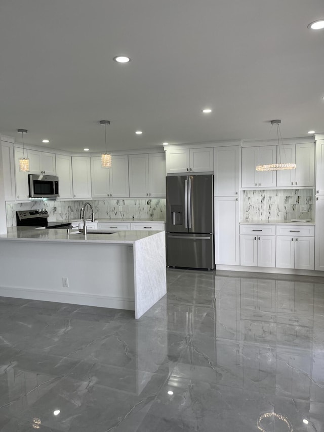 kitchen with sink, appliances with stainless steel finishes, white cabinets, and pendant lighting