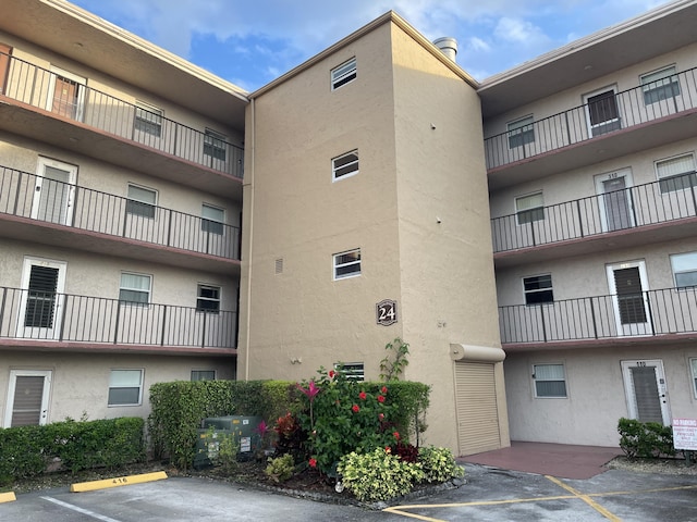 view of property with central air condition unit and uncovered parking