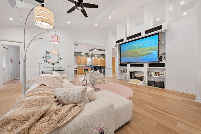 living area featuring visible vents, a ceiling fan, built in features, recessed lighting, and light wood-style floors