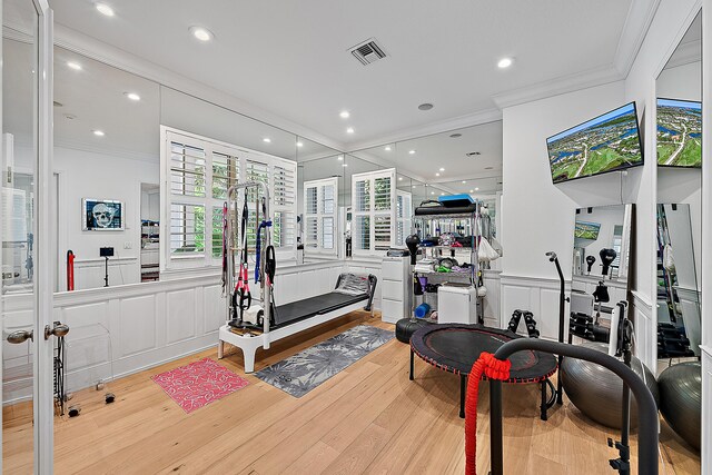 bedroom featuring a closet, ornamental molding, a tray ceiling, and wood finished floors