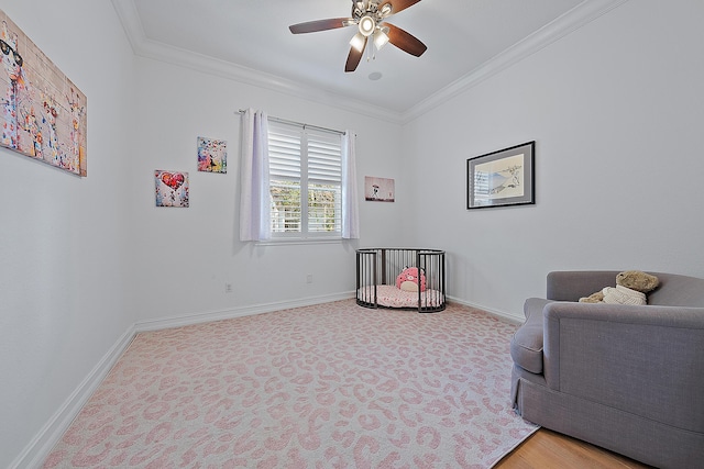 sitting room with baseboards, a ceiling fan, and ornamental molding