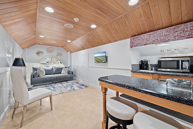 living area with a wainscoted wall, recessed lighting, wooden ceiling, and vaulted ceiling