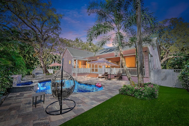 outdoor pool featuring a patio area, a yard, a deck, and fence