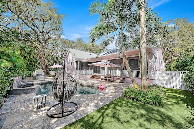 back of house with fence, an outdoor kitchen, a yard, a patio area, and metal roof