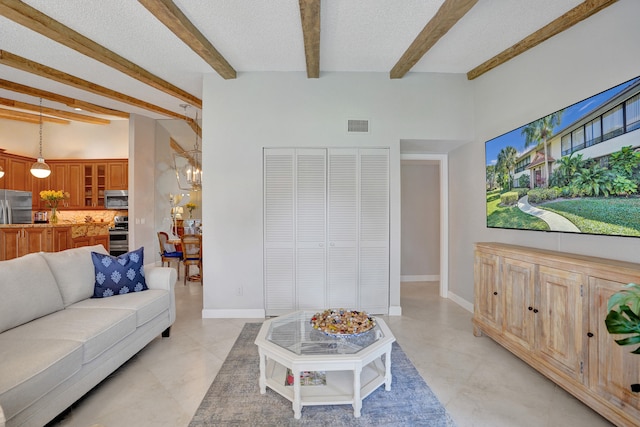 living room with a textured ceiling, baseboards, visible vents, and an inviting chandelier