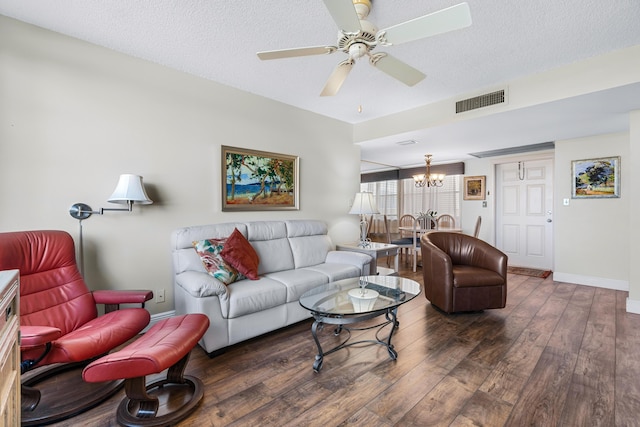 living room with ceiling fan with notable chandelier, a textured ceiling, and dark hardwood / wood-style floors