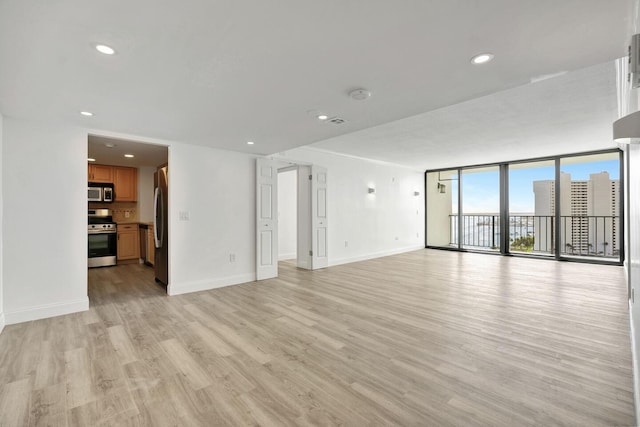 5600 N Flagler Dr Unit 1605, West Palm Beach, FL 33407 - unfurnished living room featuring light wood-style flooring, floor to ceiling windows, baseboards, and recessed lighting