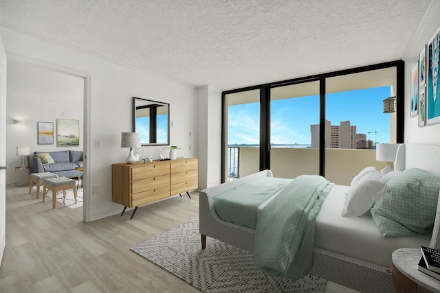 5600 N Flagler Dr Unit 1605, West Palm Beach, FL 33407 - bedroom featuring a textured ceiling, access to outside, light wood finished floors, and multiple windows