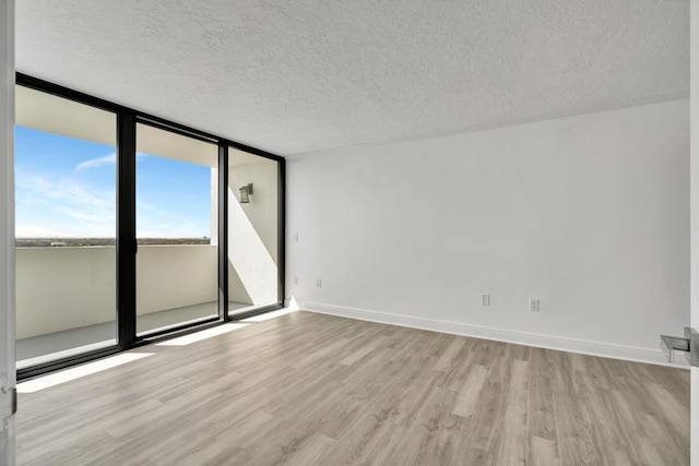 5600 N Flagler Dr Unit 1605, West Palm Beach, FL 33407 - empty room with expansive windows, baseboards, a textured ceiling, and light wood finished floors