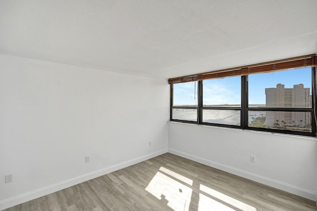 5600 N Flagler Dr Unit 1605, West Palm Beach, FL 33407 - empty room featuring a view of city, light wood-type flooring, and baseboards