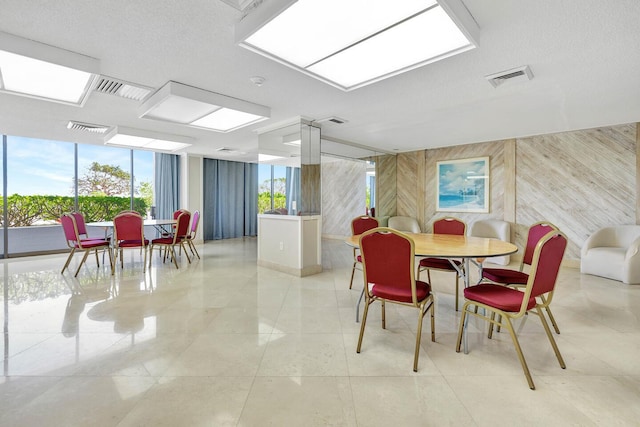 5600 N Flagler Dr Unit 1605, West Palm Beach, FL 33407 - dining area featuring wooden walls, visible vents, and a healthy amount of sunlight