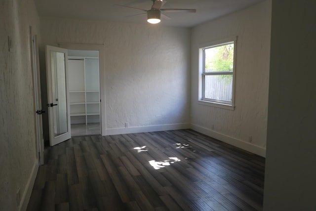 unfurnished bedroom with a closet, baseboards, and dark wood-style flooring